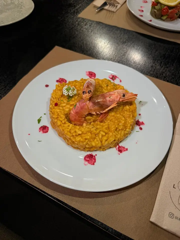 Risotto meloso de marisco coronado con gambas a la plancha