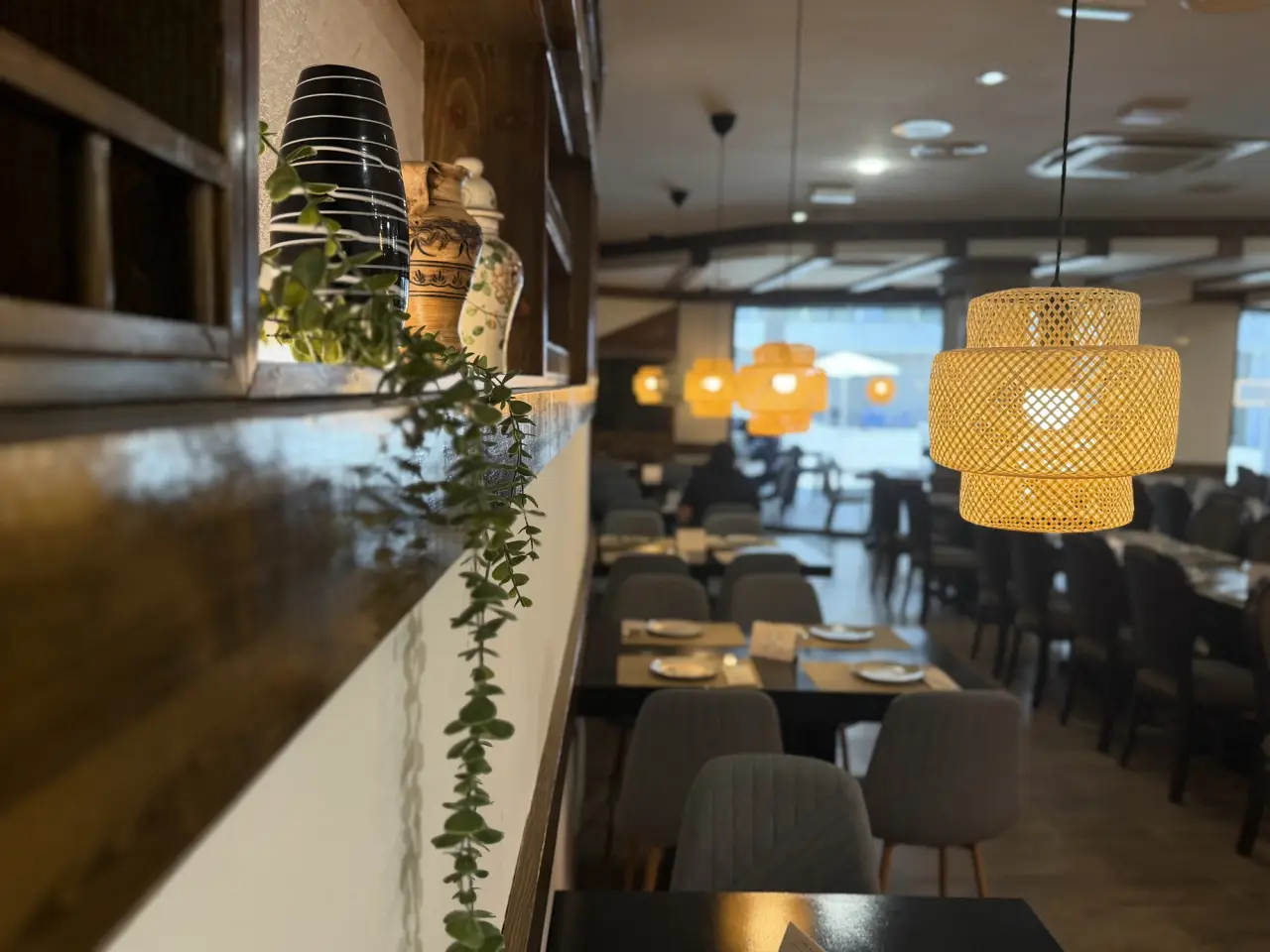 Comedor de Limbo con lámparas colgantes, plantas y luz cálida